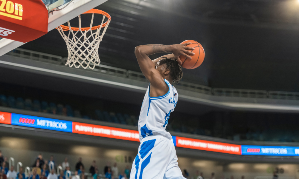 A basketball player jumping to dunk a basketball